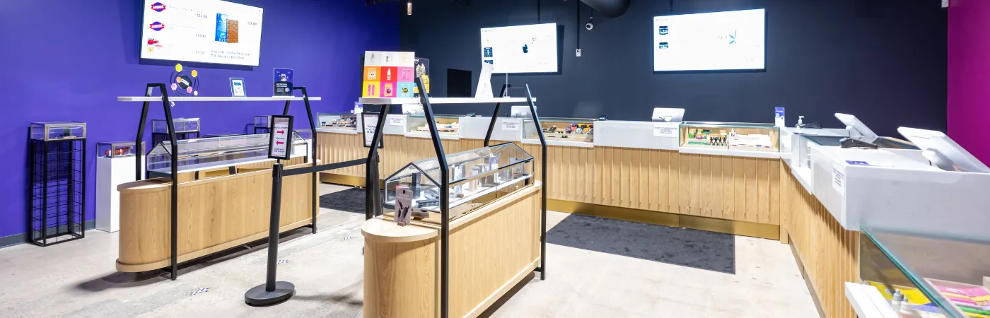 Modern retail store interior with glass display cases and digital price screens on vibrant purple and black walls