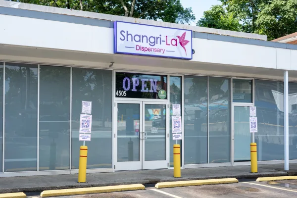 storefront with a sign reading 'Shangri-La' and an 'OPEN' sign on the door